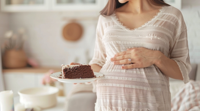 milkie blog tehotenstvi cukrovka closeup-pregnant-woman-holding-plate-with-chocolate-cake-slice